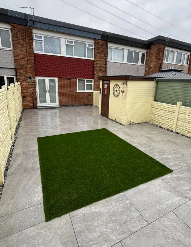 Artificial grass garden with cream fencing and garden clock feature