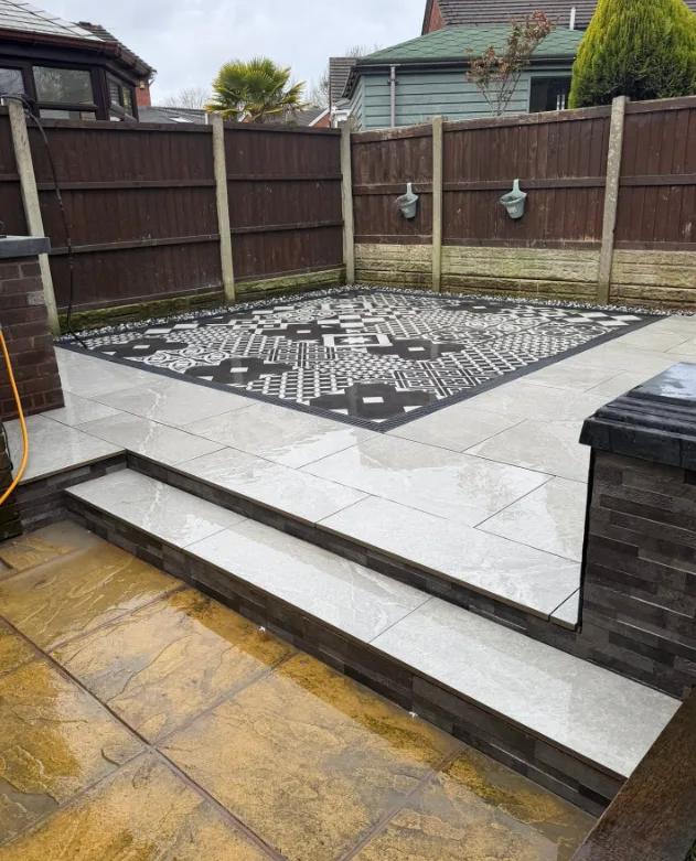 Patio with decorative mosaic-pattern paving inset and steps