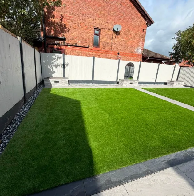 Full width artificial grass garden with stone borders