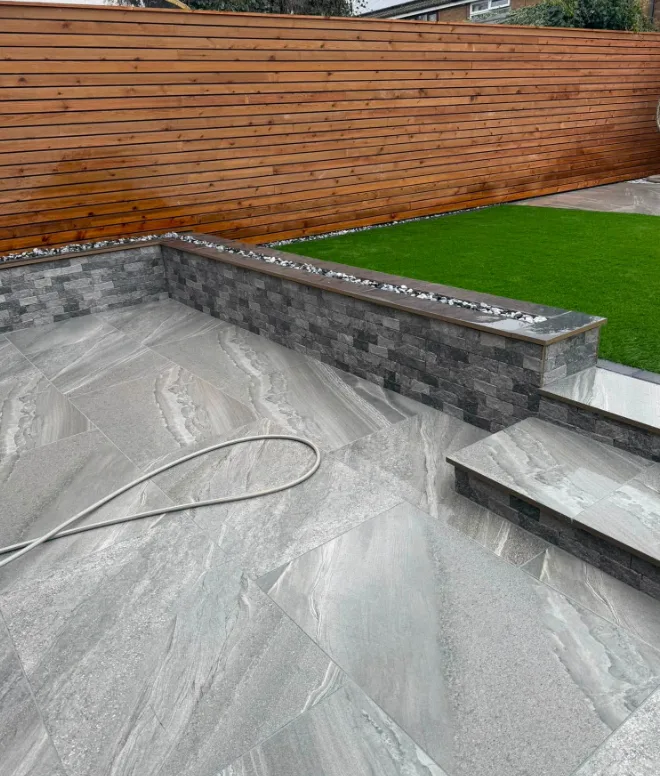 Stone-effect patio with retaining wall and steps