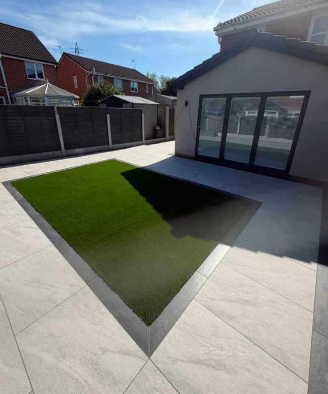 Wide garden lawn with brick house and pale fencing